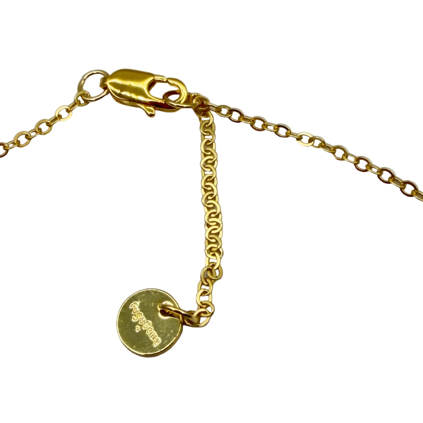 Gold bracelet with a round tag on a light gray background