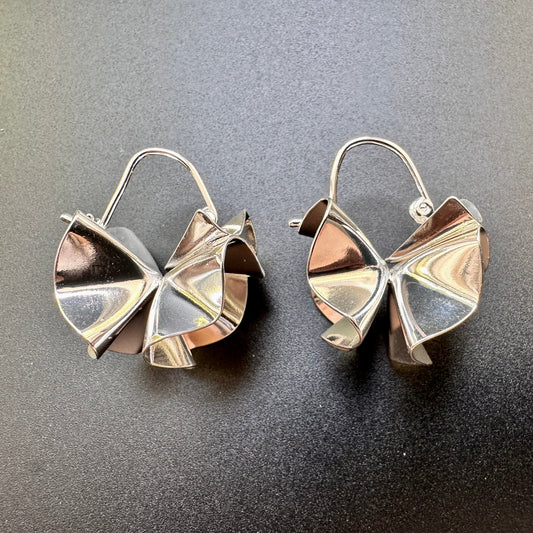 Pair of silver butterfly-shaped earrings on a gray background