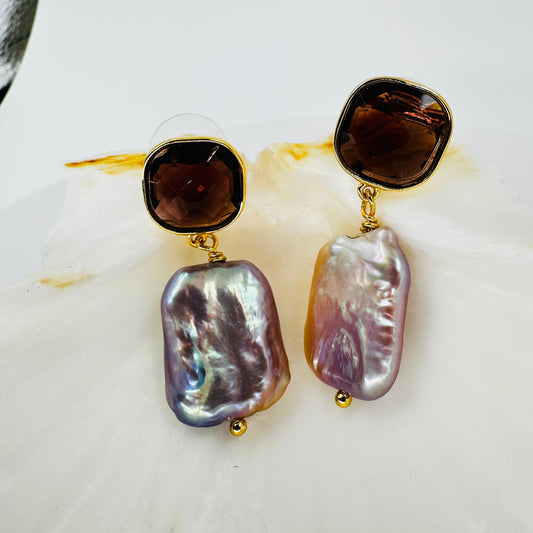 Close-up of faceted purple zirconia and iridescent baroque pearl