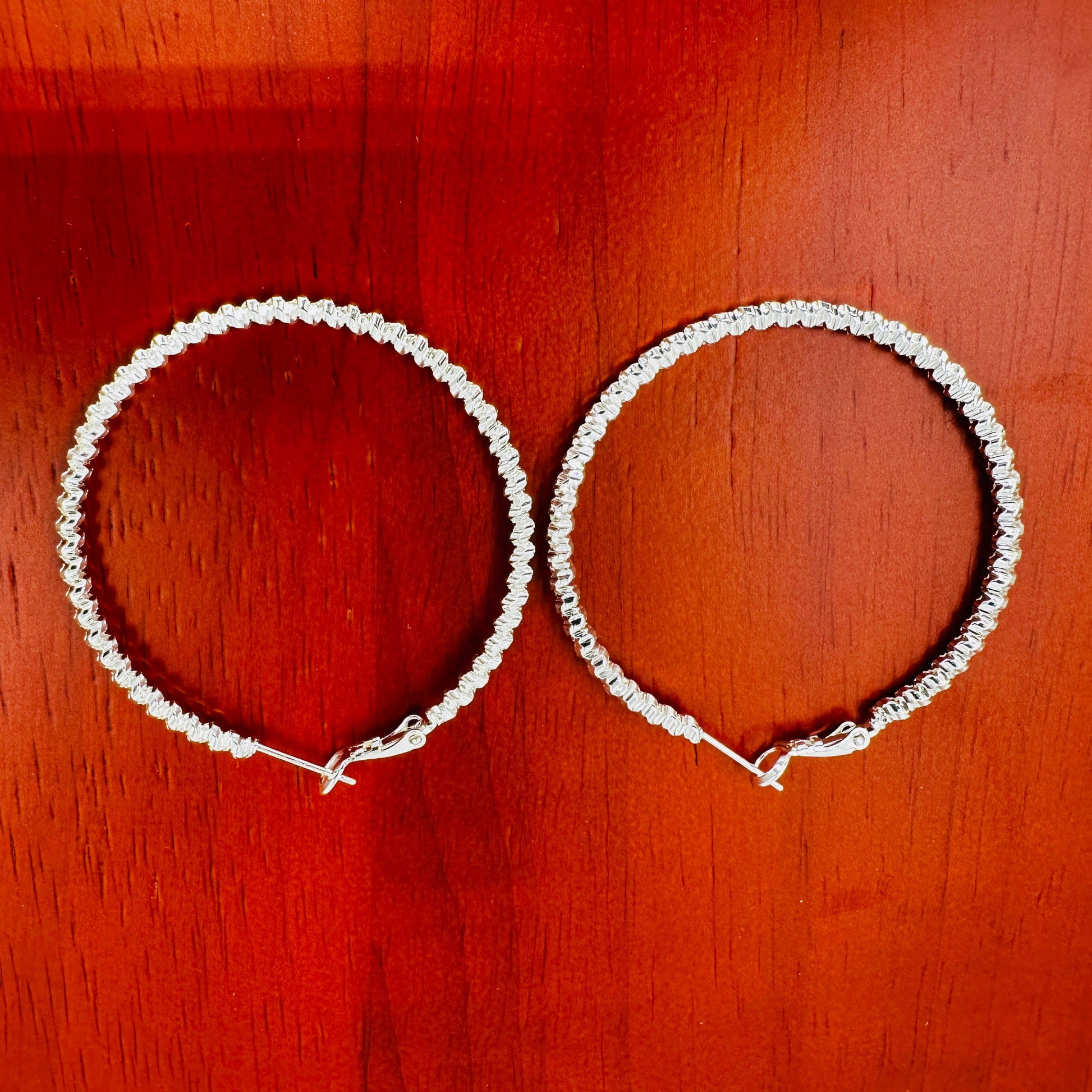 Side view showing depth and curvature of woven hoop earrings