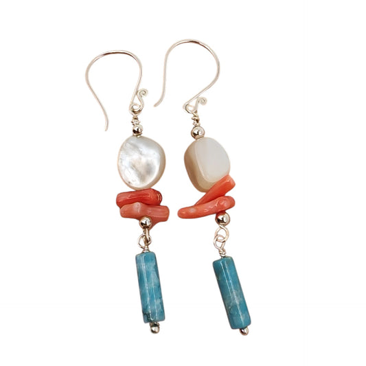 Close-up of white shell, red coral, and blue agate on silver chain