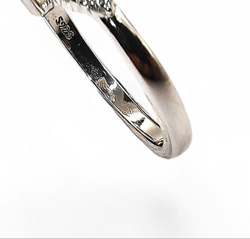 Diamond ring with a central gemstone and smaller diamonds on a white background