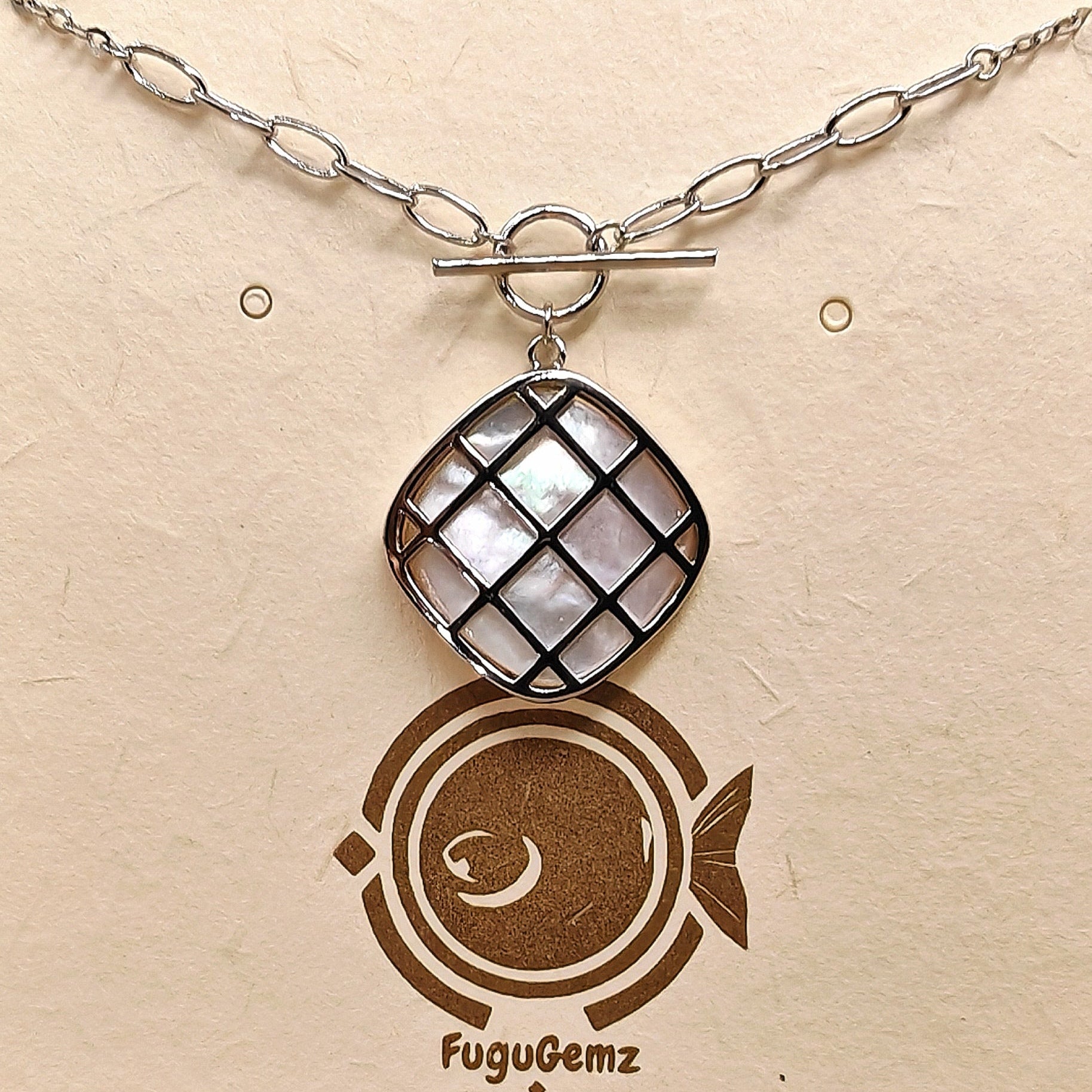 Close-up of square pendant and silver casement