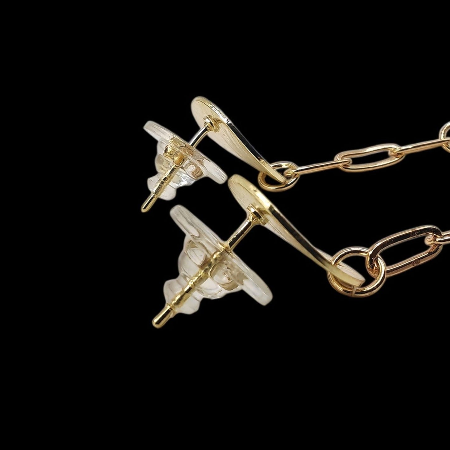 Gold and pearl earring on a black background