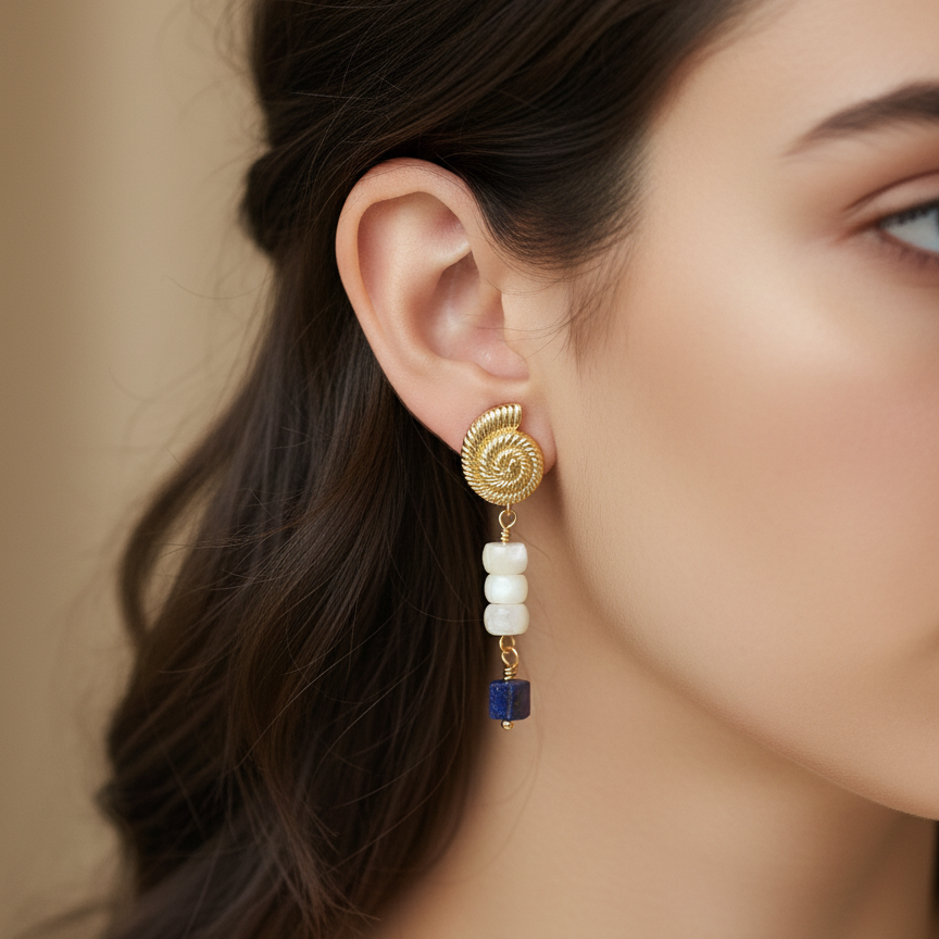 Woman wearing gold and blue gemstone earrings on ears