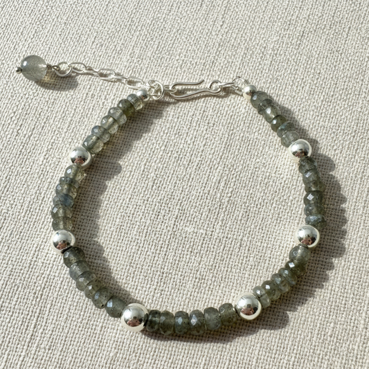 17cm labradorite bracelet with 42x4.5mm faceted beads and 6x5.8mm 925 plated beads on beige background