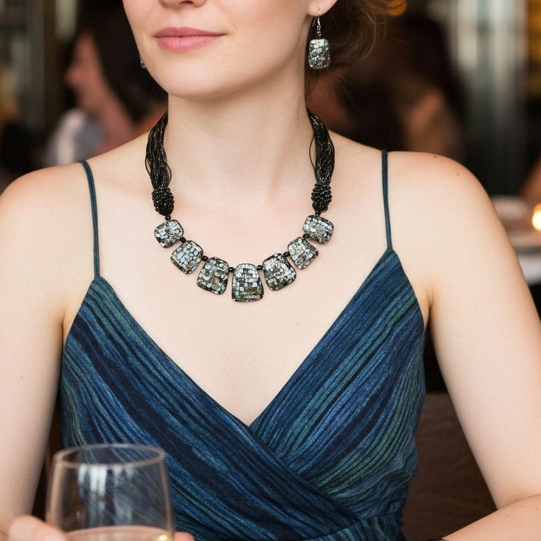 Woman wearing abalone shell necklace with black cord and tassel