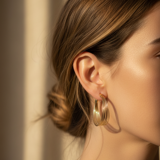 Woman wearing multi-layer hoop earrings with natural makeup and loose hair
