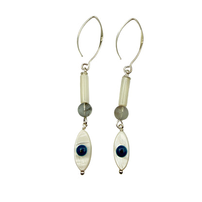 Pair of earrings with white beads, blue stones, and silver hooks on a light gray background
