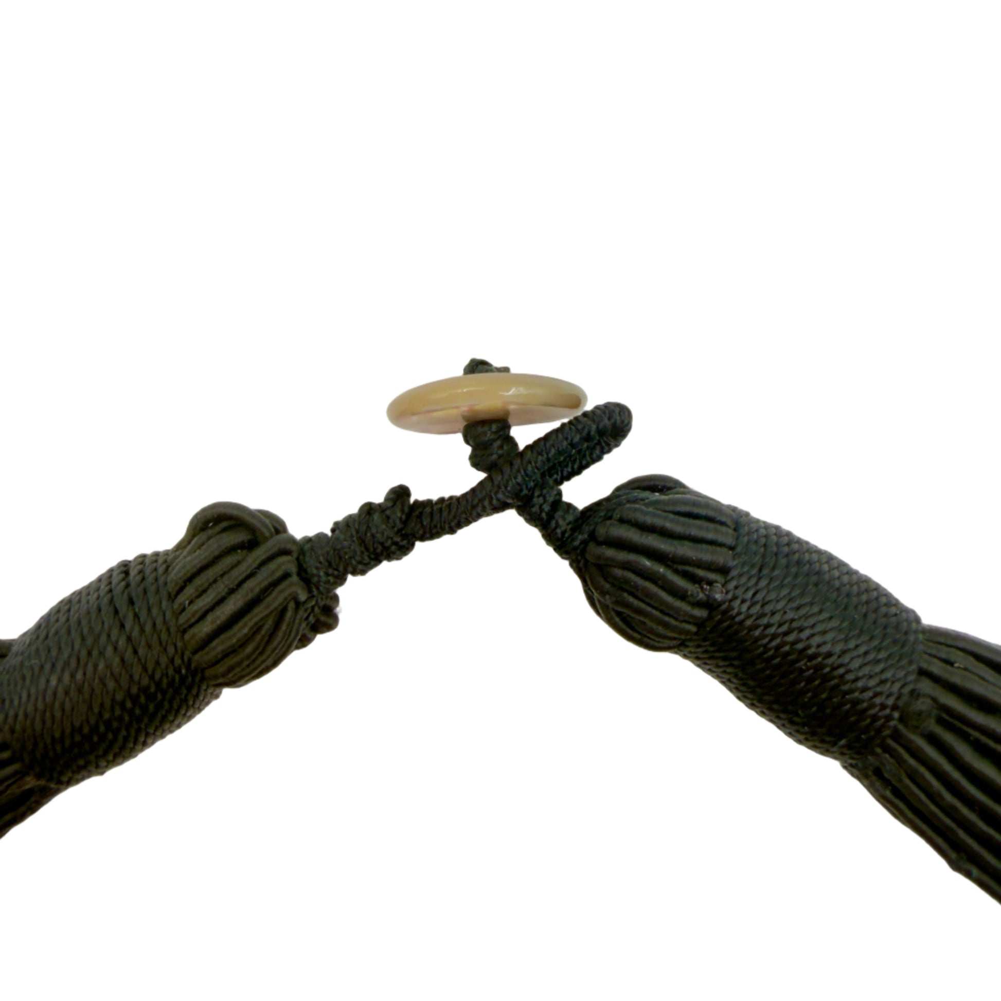 Close-up of a black tassel with a wooden ring on a white background