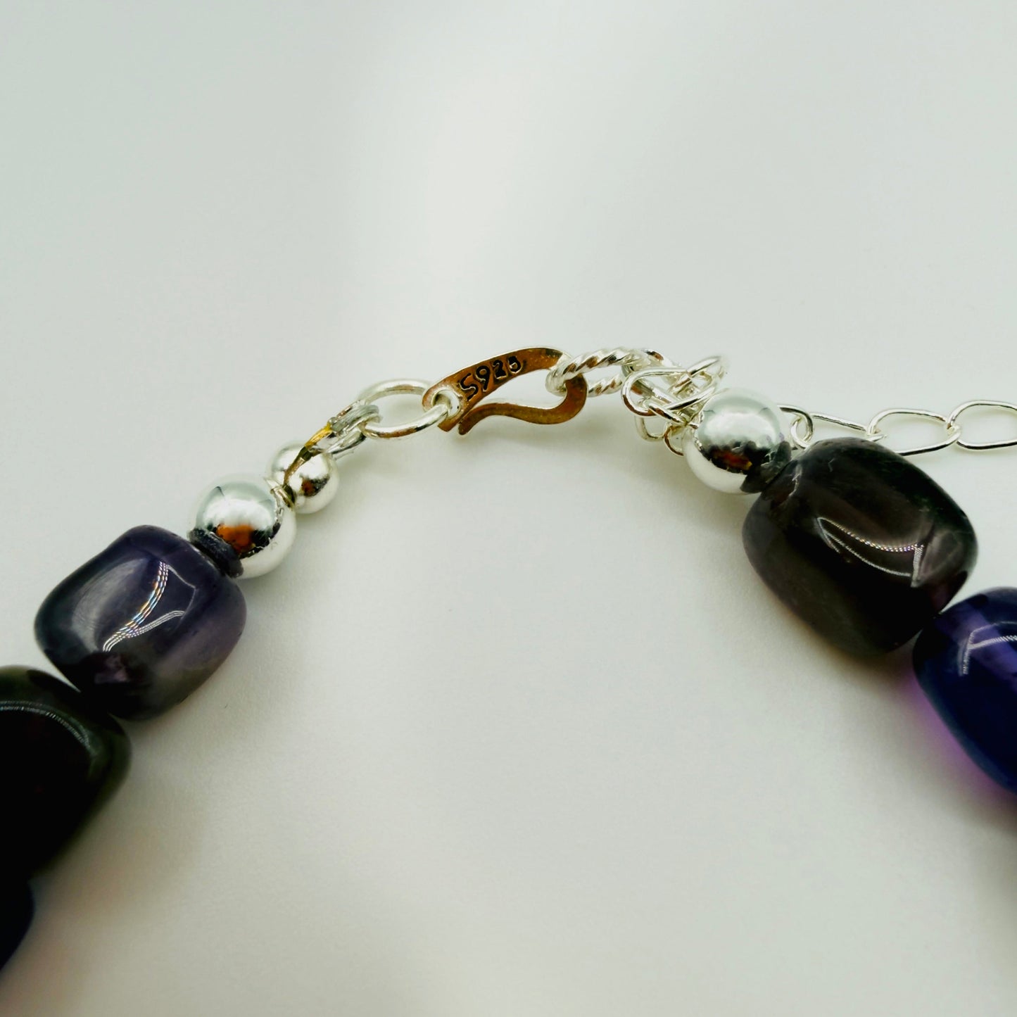 Bracelet with black and purple beads on a white background