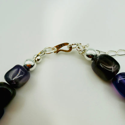 Bracelet with black and purple beads on a white background