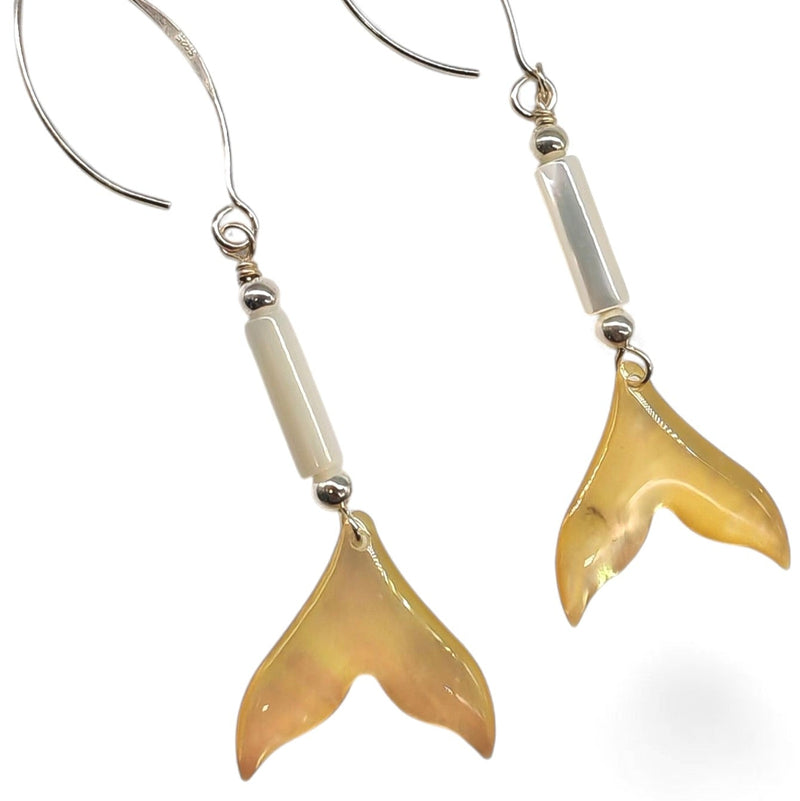 Pair of gold fish tail earrings on a white background