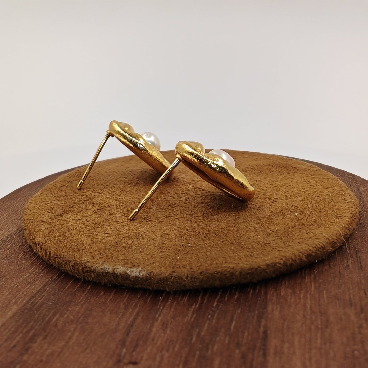 Back view of brass leaf earrings showing silver needle post