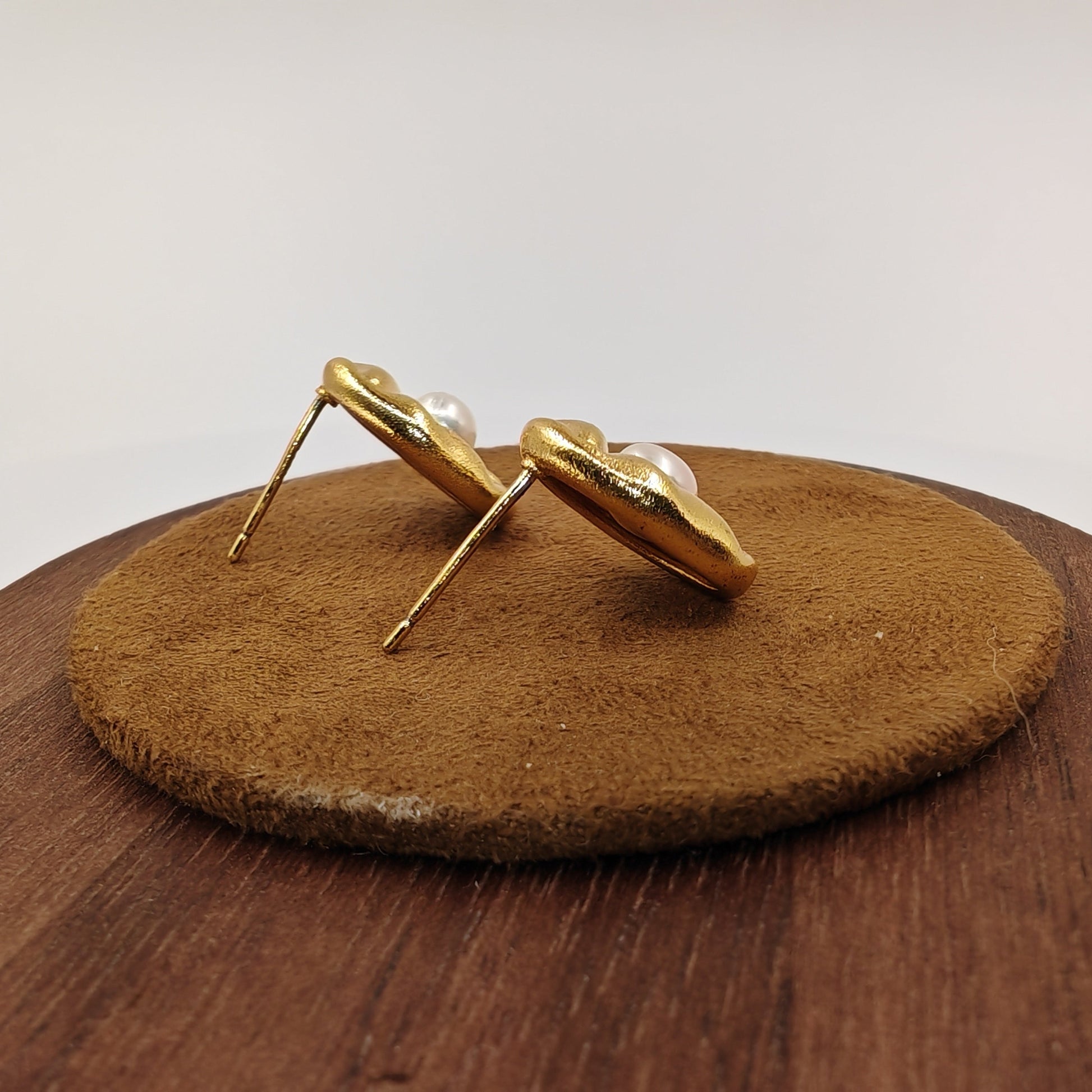 Back view of brass leaf earrings showing silver needle post