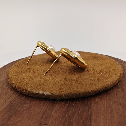 Back view of brass leaf earrings showing silver needle post