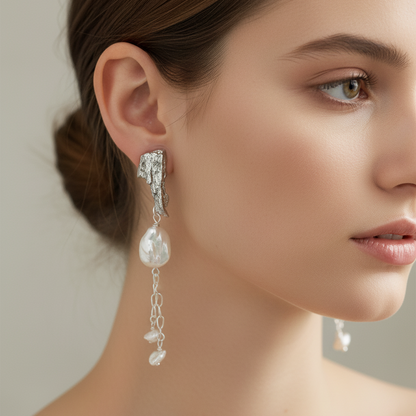 Woman wearing platinum and pearl earrings on ears
