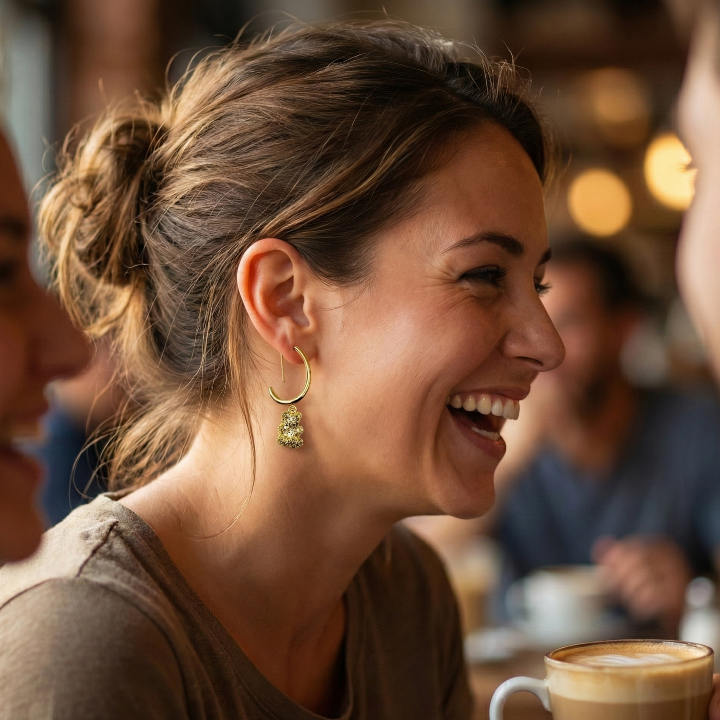 Woman wearing gold-plated bear charm earrings with casual top
