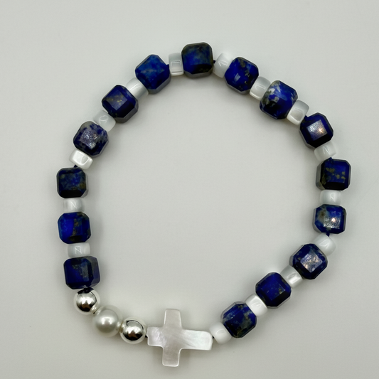 A 15cm stretch bracelet featuring blue lapis lazuli beads, a white cultured pearl, and a mother of pearl cross.