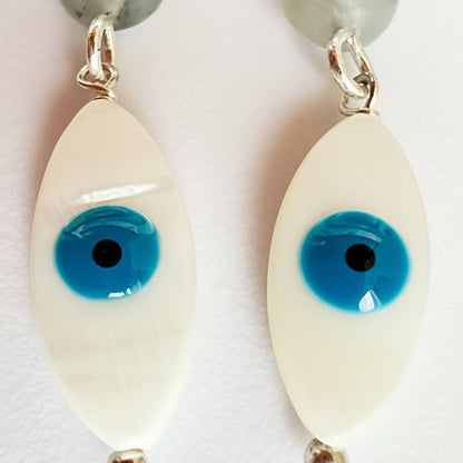 Eyeball-shaped earrings with blue pupils on a white background