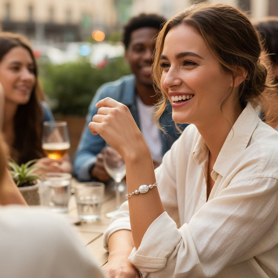Woman smiling at a social gathering with drinks and friends around her.