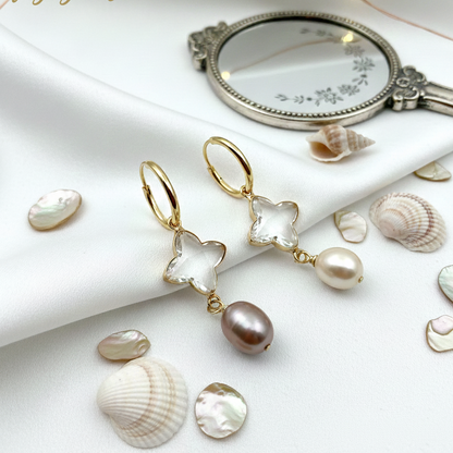 Pearl and star-shaped earring with seashells on a white surface, featuring 'fugugemz.com' branding.