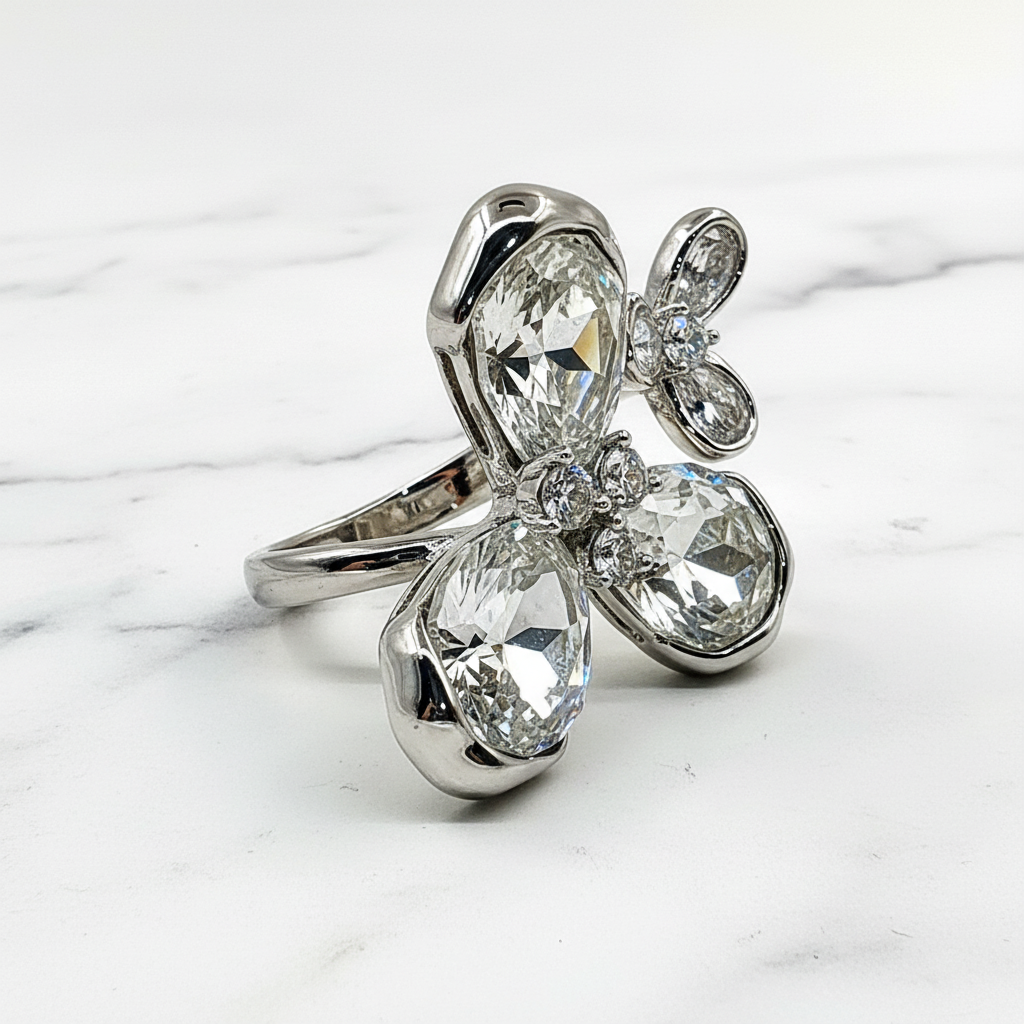 Silver ring with large clear gemstones on a marble surface